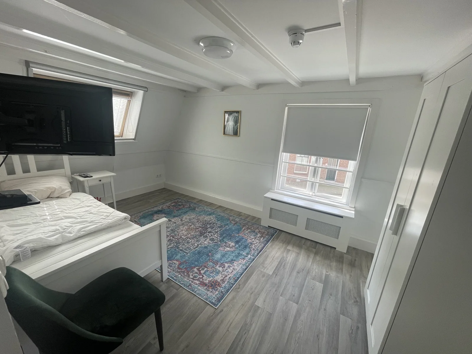 Een kamer in de woonvorm, met bed, kast en raam